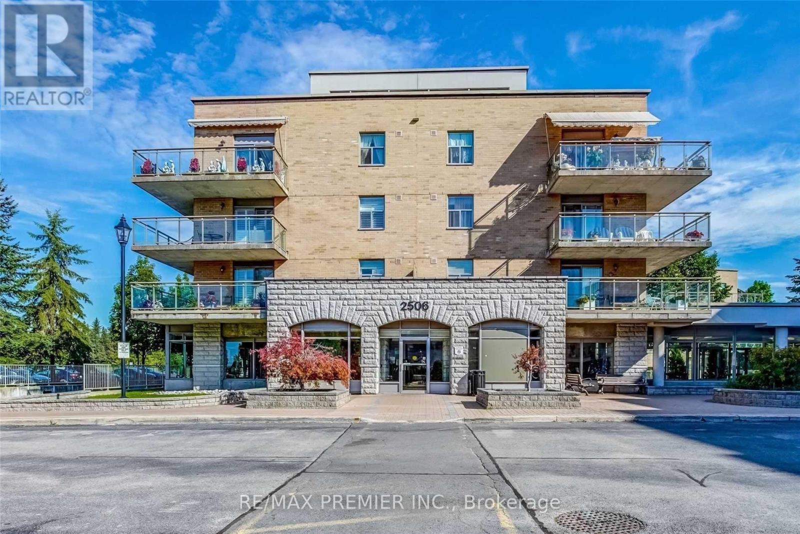 A multi-story building with balconies is under the sign RE/MAX Premier Inc. Brokerage.