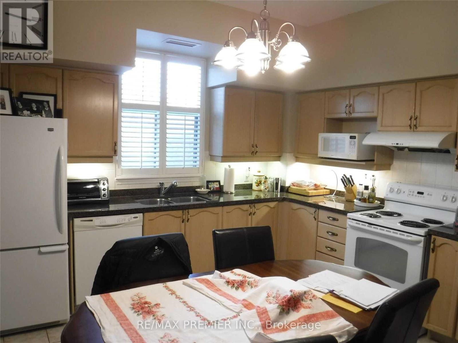 A kitchen with a table and chairs in the middle.