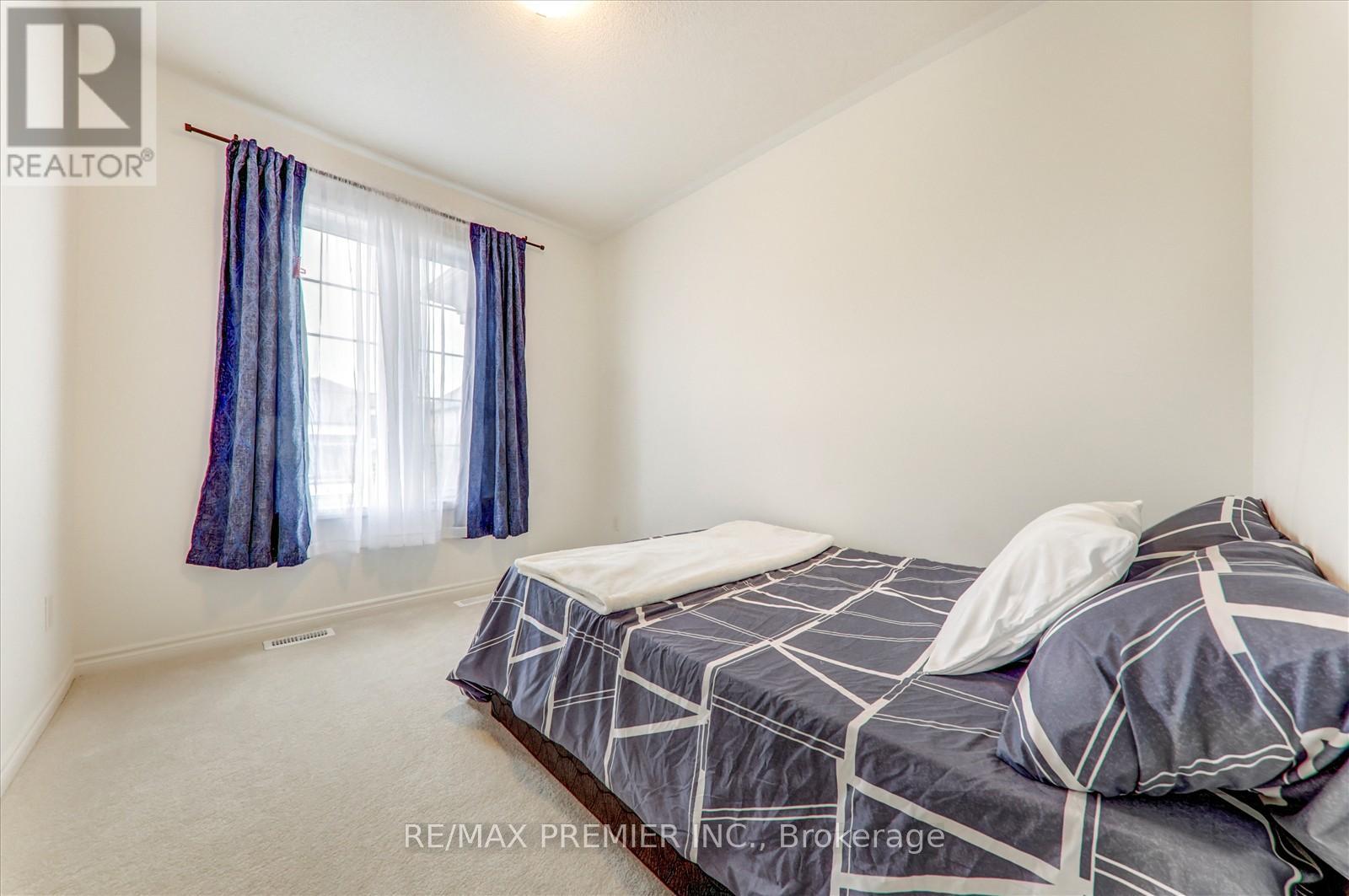 A bedroom with a bed and a window with blue curtains.