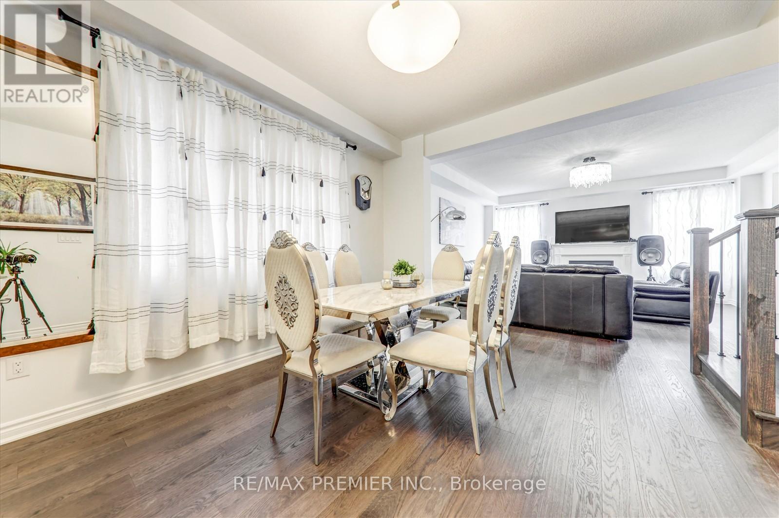 A dining room with a table set for four and a couch in the background.