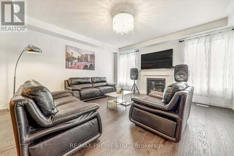 A living room with black leather furniture and a chandelier.