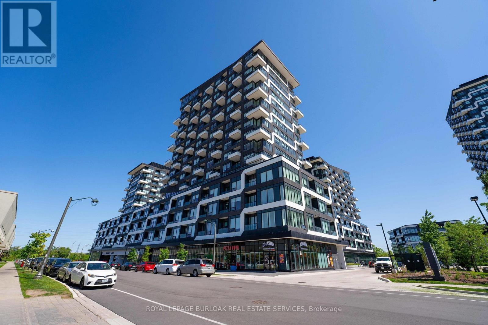 A tall building with a glass facade is the main focus of the image.