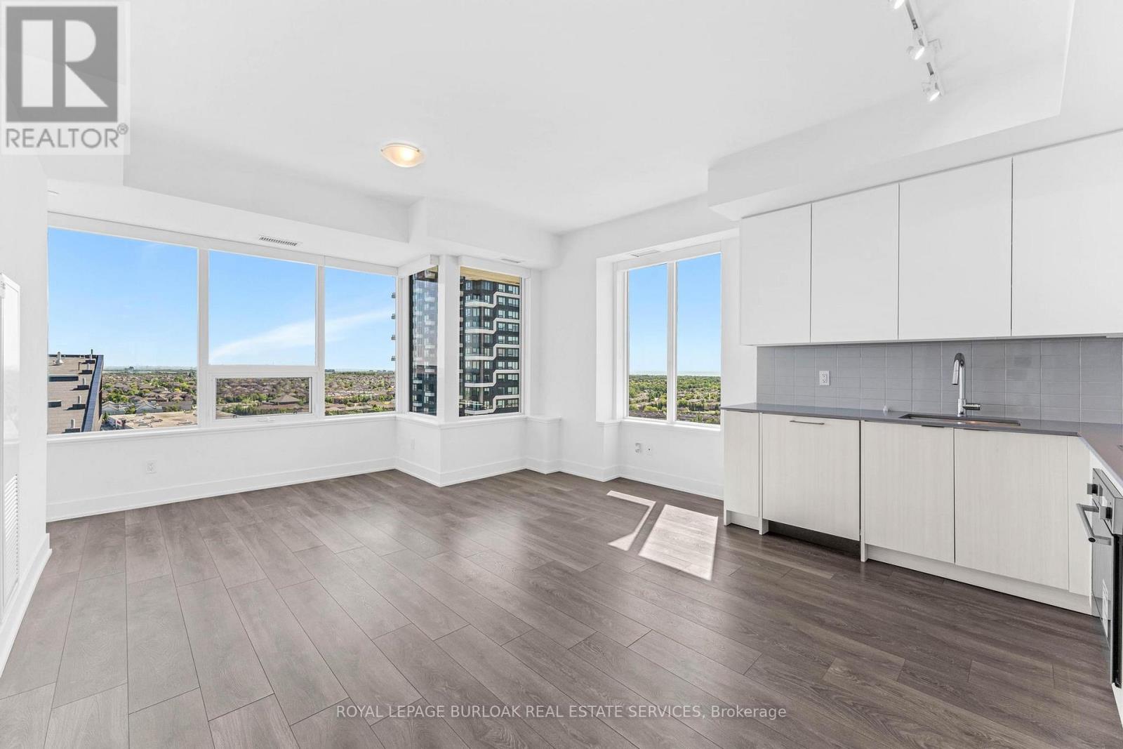 A spacious room with a large window overlooking a cityscape.