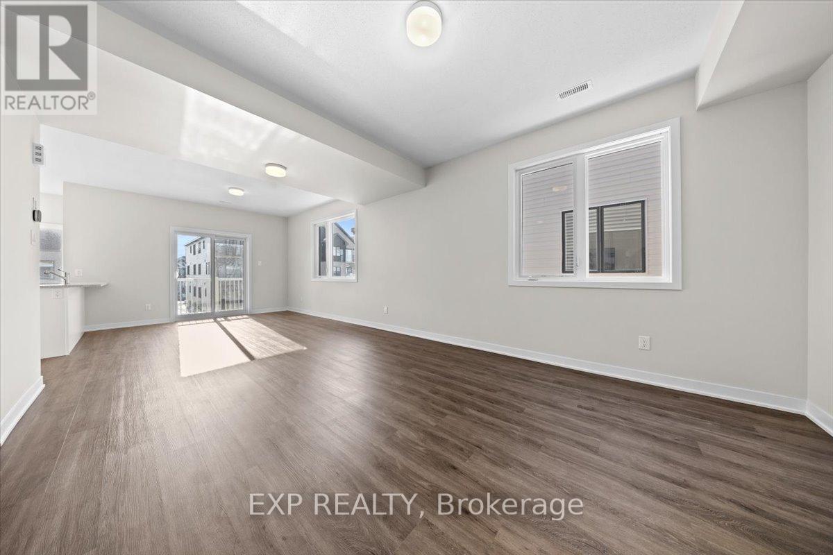 A spacious room with wooden flooring and a large window.