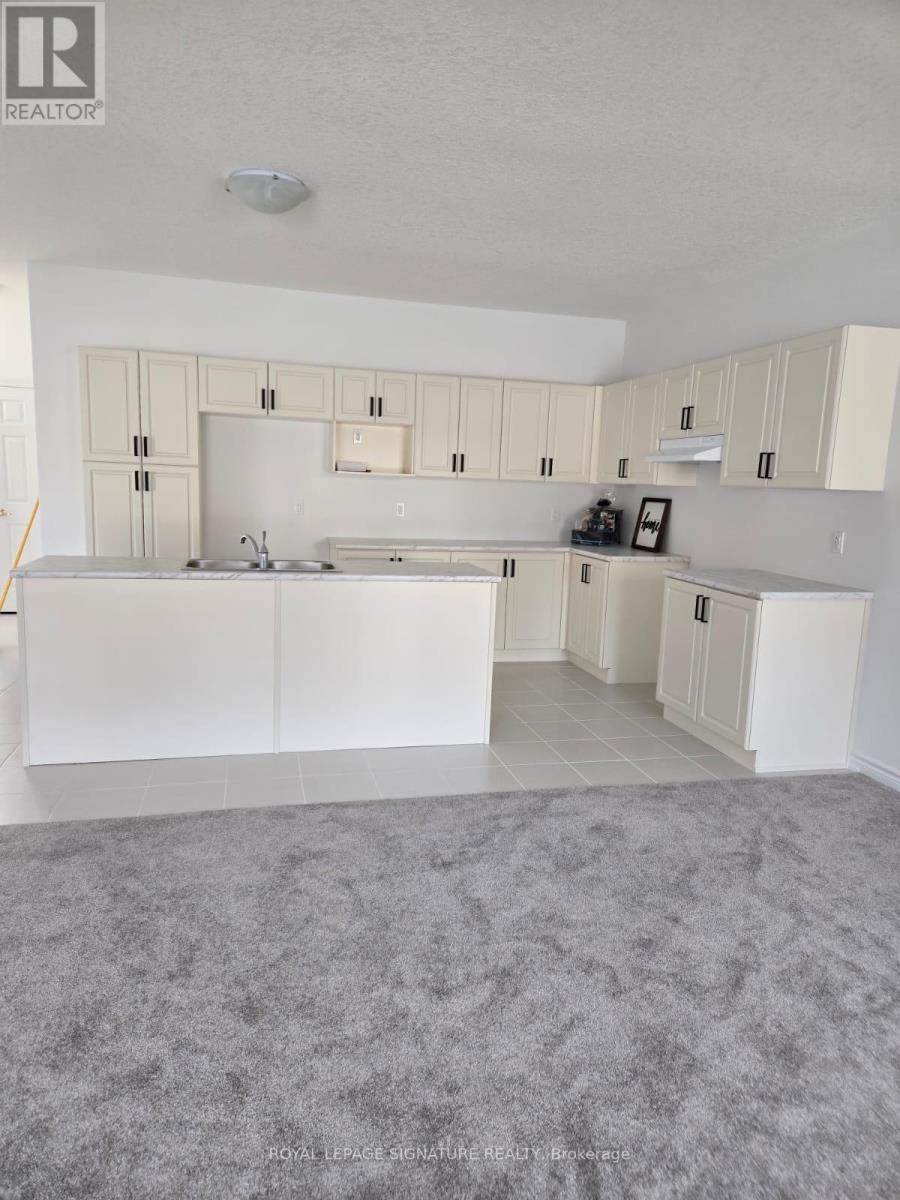 A realtor photo of a white kitchen with a grey carpet.