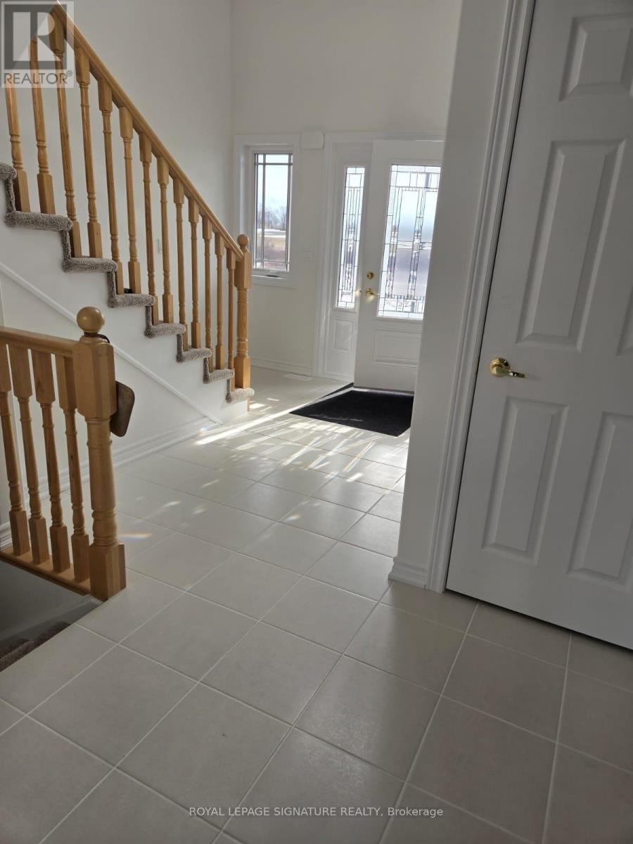 A white door is open to a hallway with a staircase.