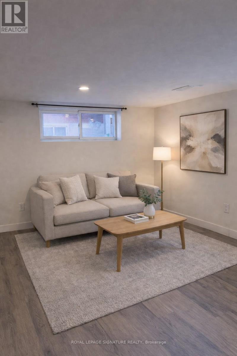 A living room with a couch, a coffee table, and a painting on the wall.