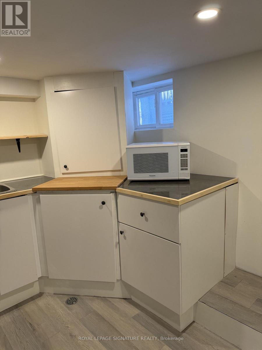 A kitchen with white cabinets and a wooden countertop.