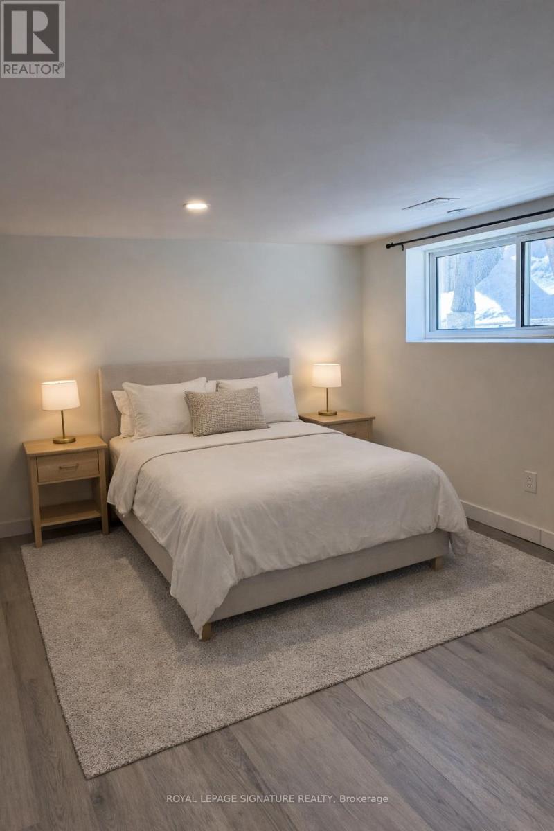 A bedroom with a large bed and two lamps.