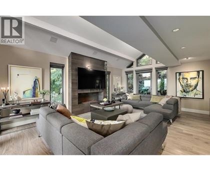 A modern living room with a grey sofa and a fireplace.