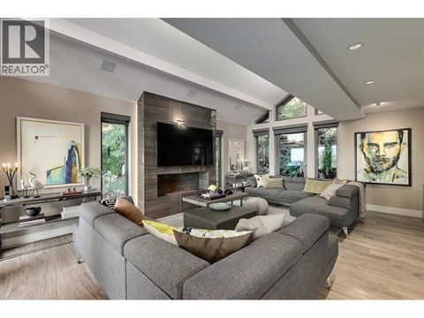 A modern living room with a grey sofa and a fireplace.