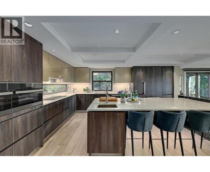 A modern kitchen with dark wood cabinets and a central island.