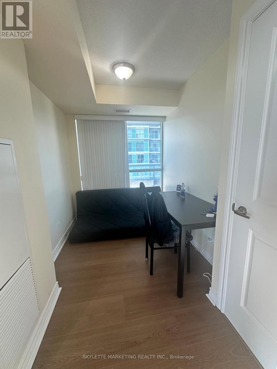 A room with a table and chairs and a window with blinds.