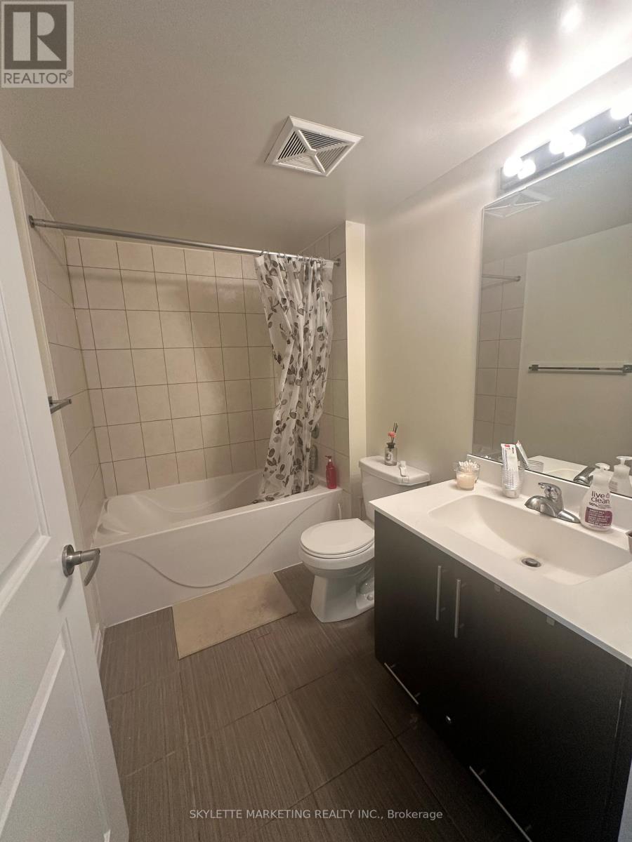 A bathroom with a white tub, toilet, and sink.