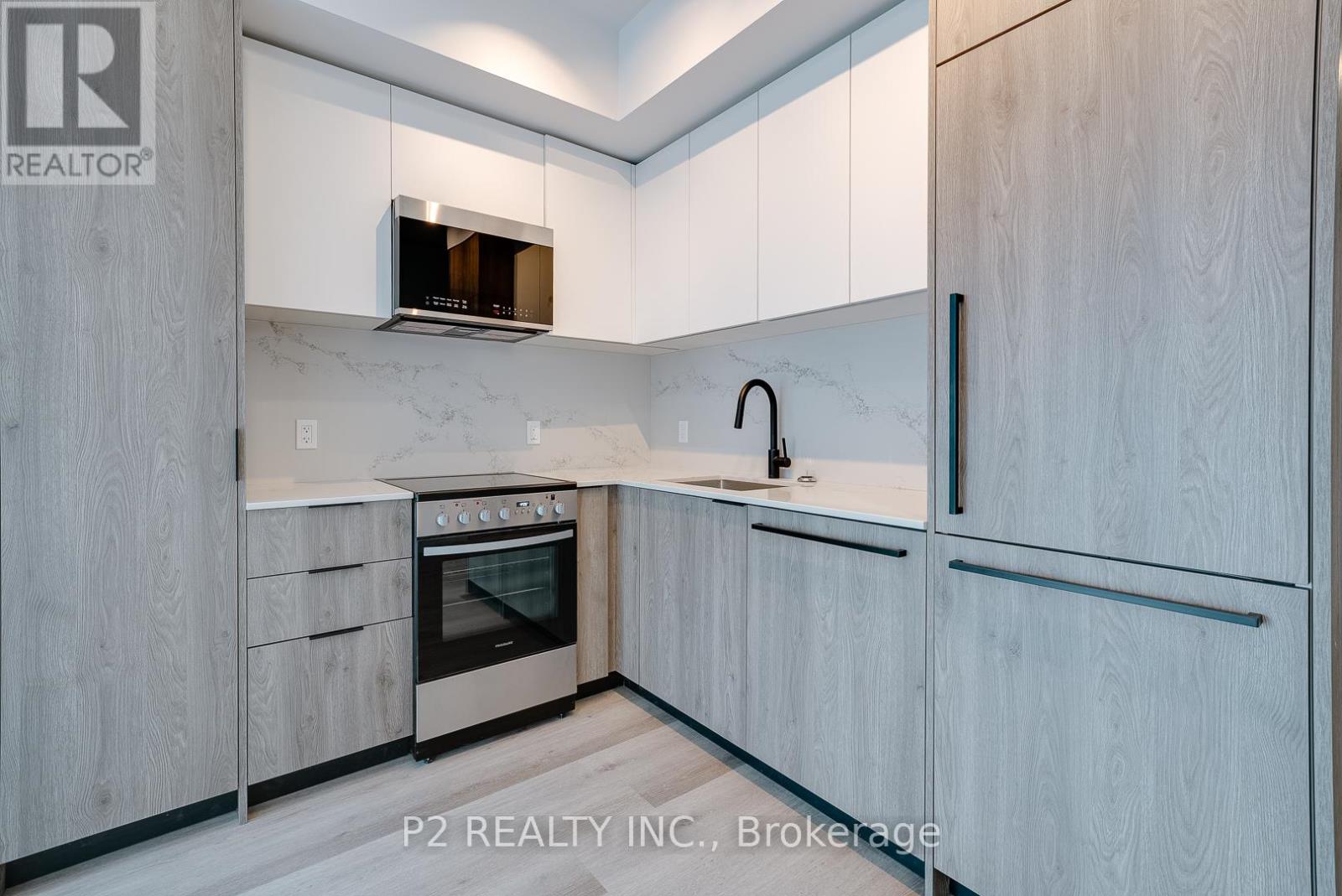 A modern kitchen with a stainless steel oven and a microwave above it.