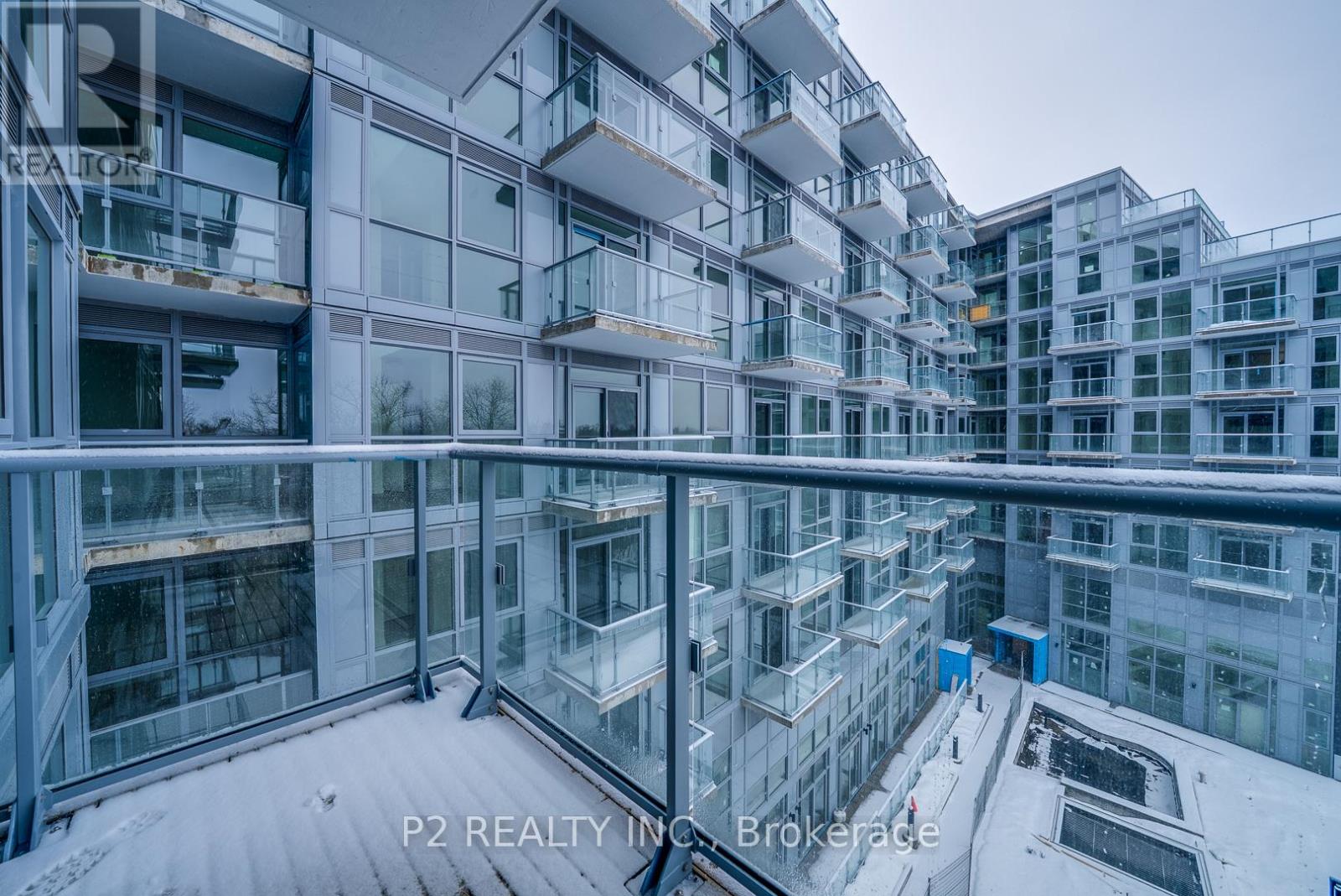 A modern glass and steel building with balconies and walkways.
