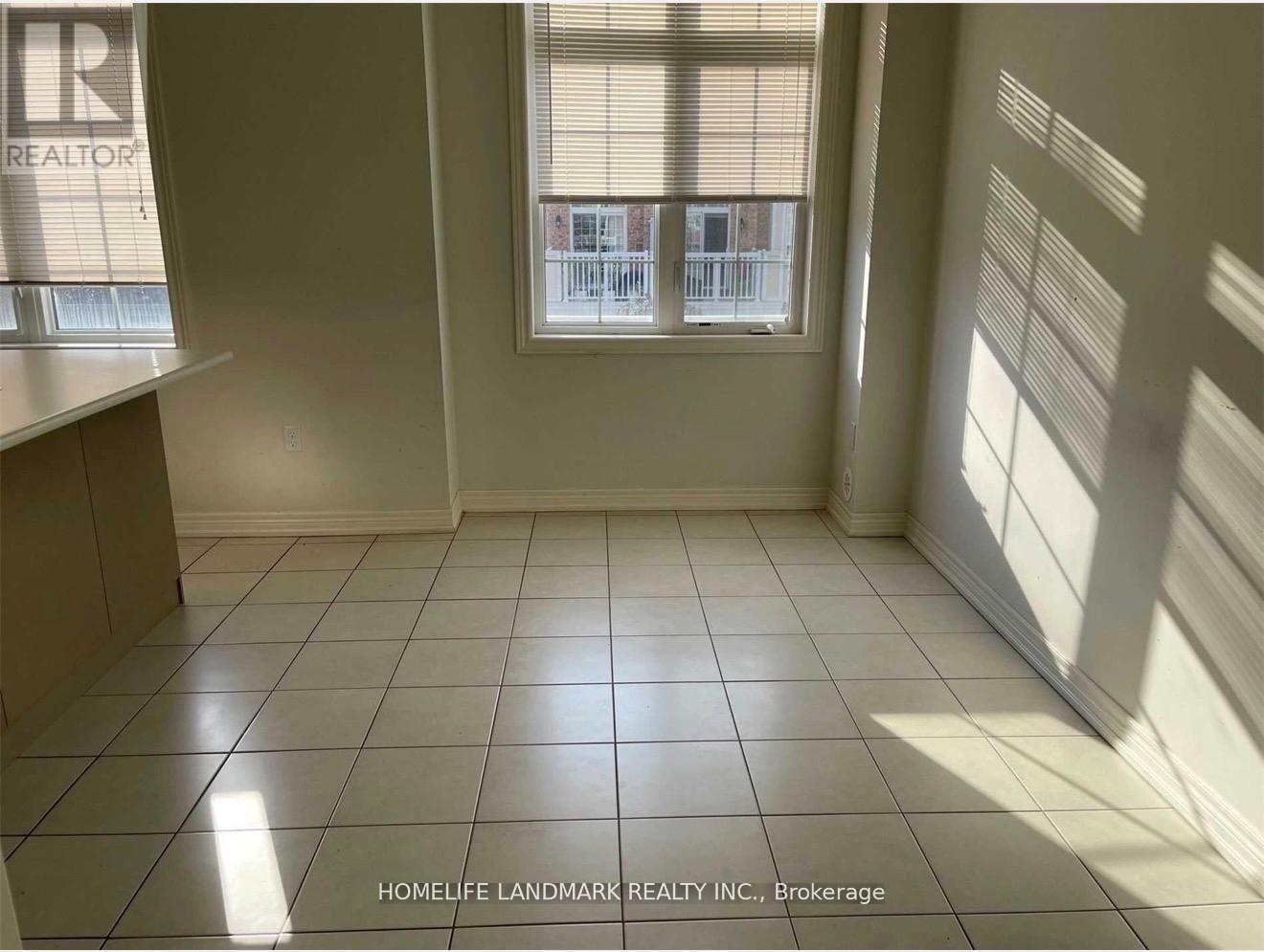 A room with a tiled floor and a window showing a balcony.
