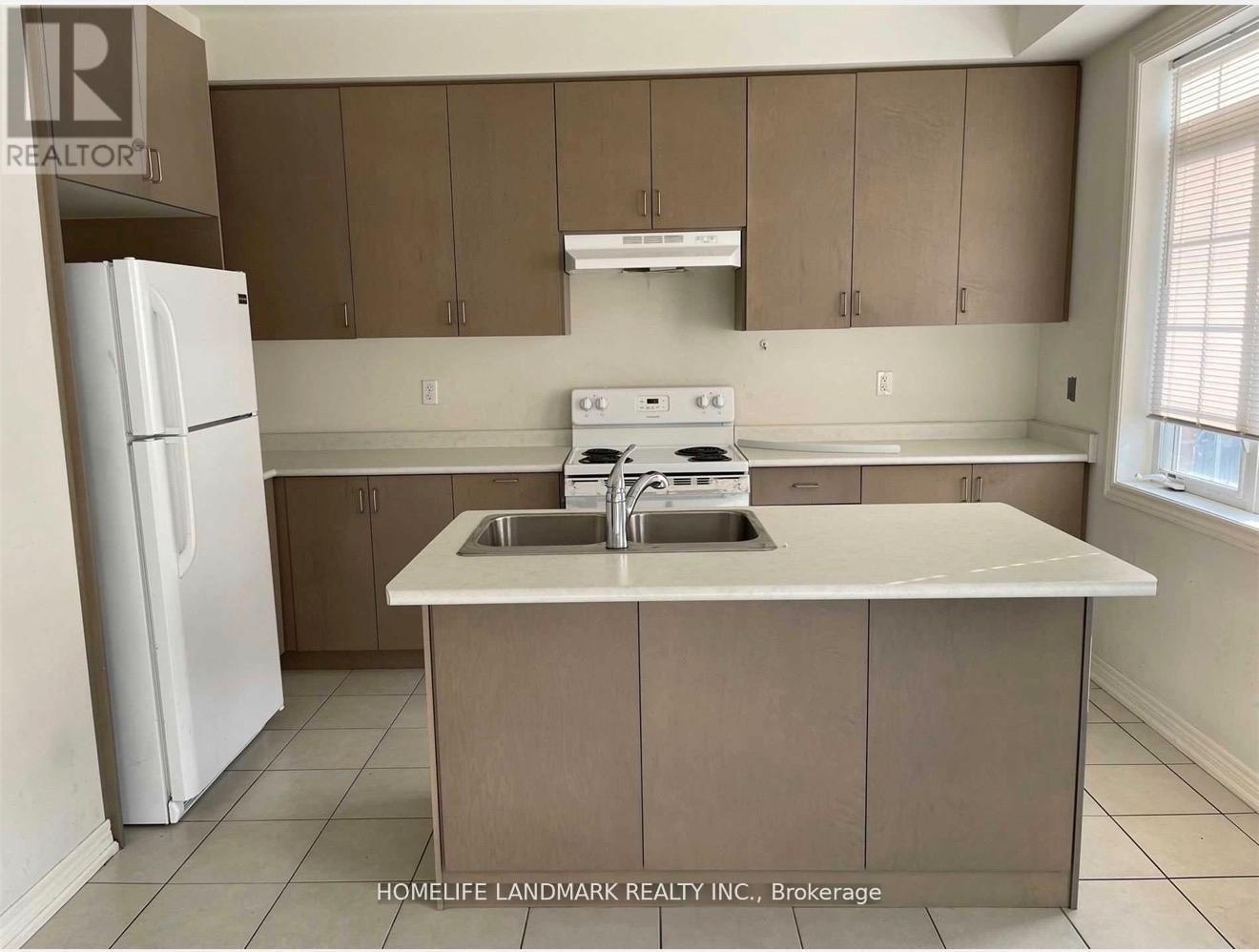 A kitchen with brown cabinets and a white fridge.