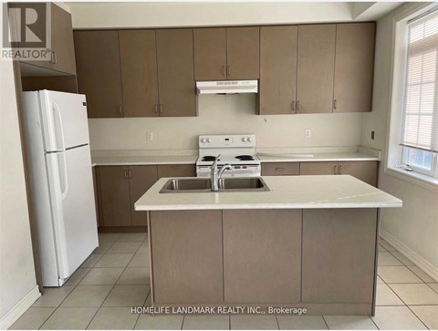 A kitchen with brown cabinets and a white fridge.