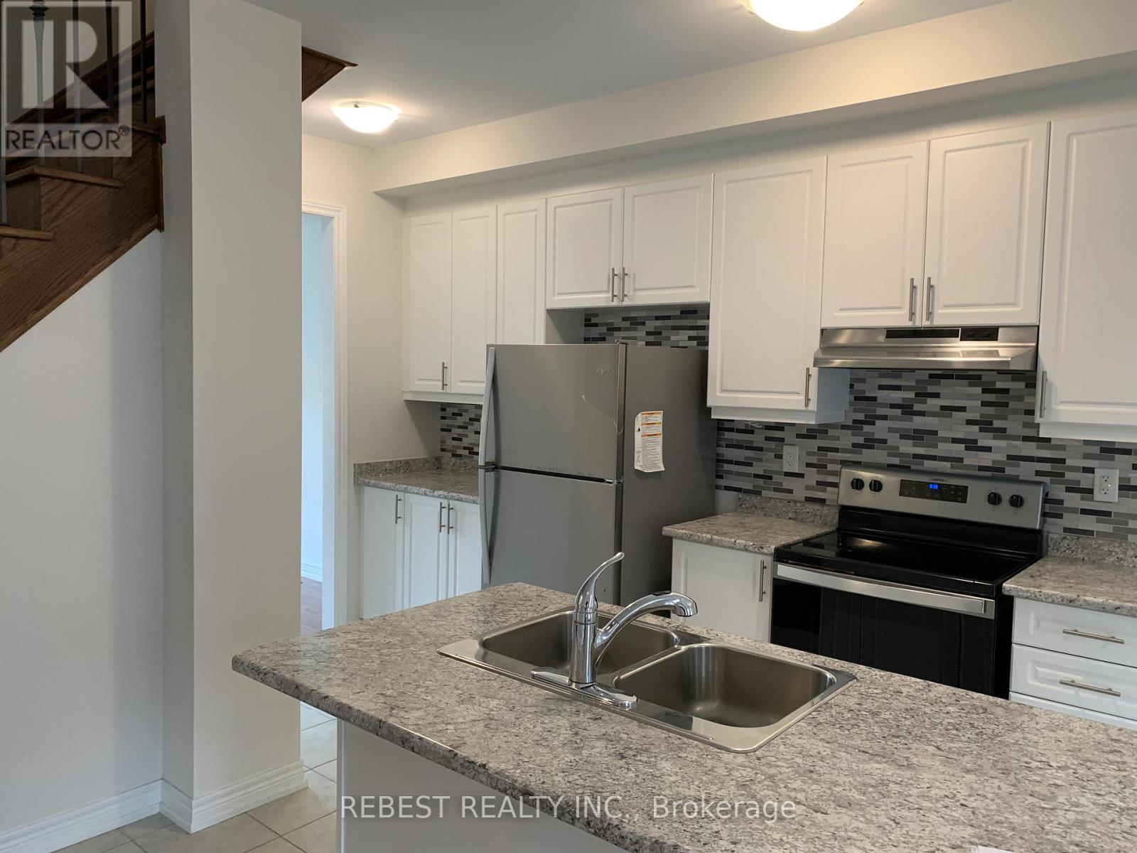 A kitchen with granite countertops and white cabinets.