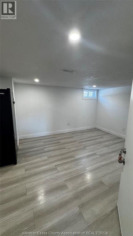 A room with a wooden floor and a small window.