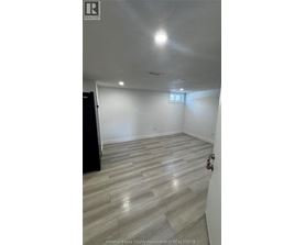 A room with a wooden floor and a small window.