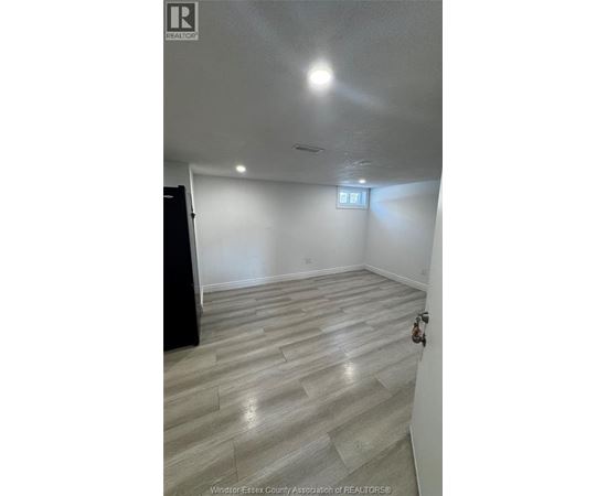 A room with a wooden floor and a small window.