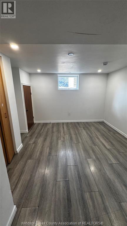 A room with wooden flooring and a window.