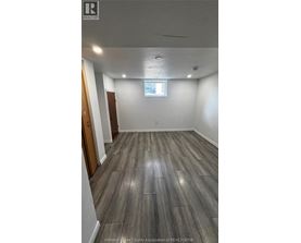 A room with wooden flooring and a window.