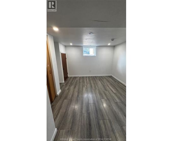 A room with wooden flooring and a window.