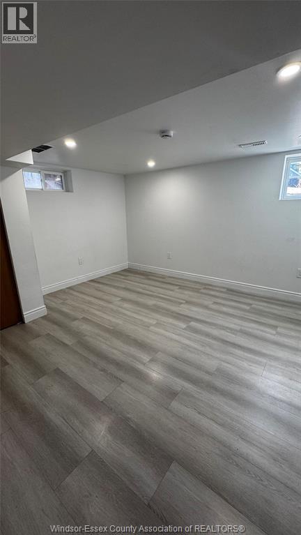 A room with wooden flooring and white walls.