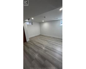 A room with wooden flooring and white walls.