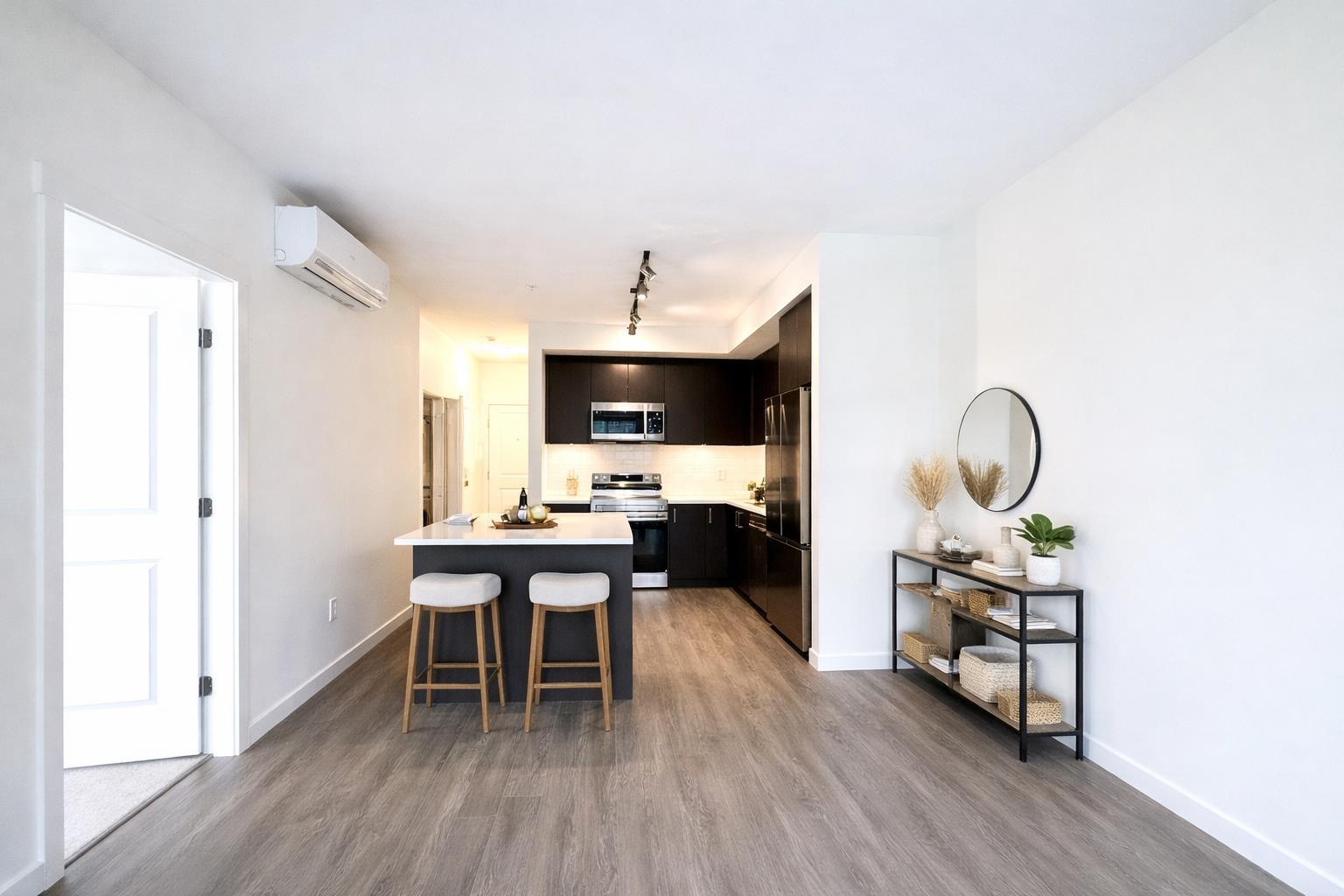 A modern kitchen with a bar stool and a small shelf with decorative items.