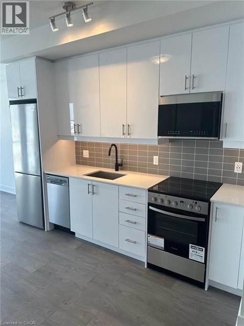 A kitchen with white cabinets and a black countertop.