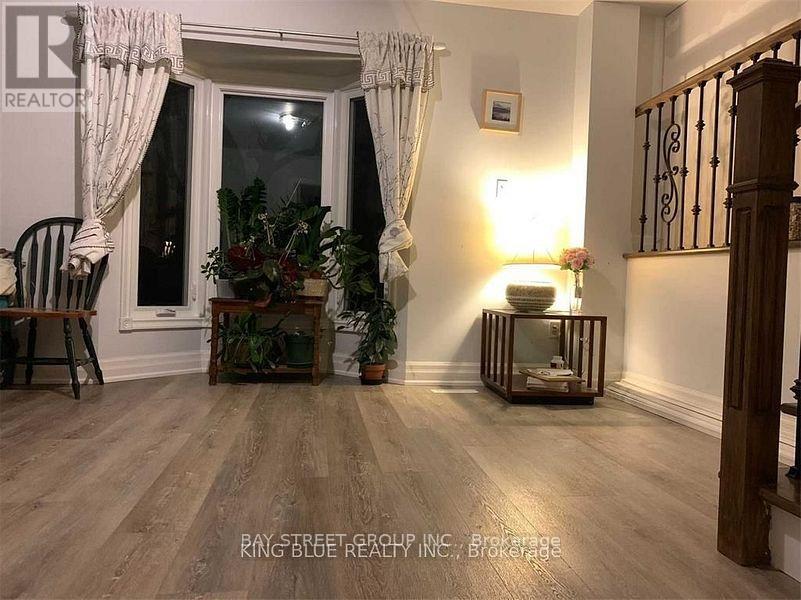 A room with wooden floors and a window with curtains.