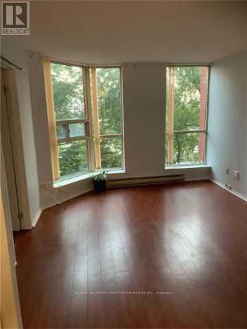 A room with wooden floors and large windows.