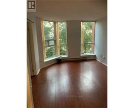 A room with wooden floors and large windows.