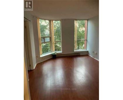 A room with wooden floors and large windows.