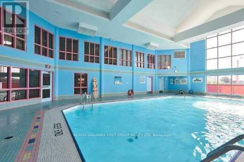 A large indoor swimming pool with a blue tiled floor and walls.