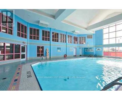 A large indoor swimming pool with a blue tiled floor and walls.