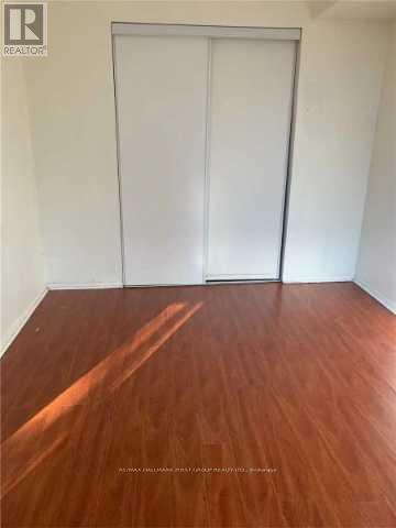 A room with a wooden floor and a white door.
