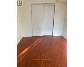 A room with a wooden floor and a white door.