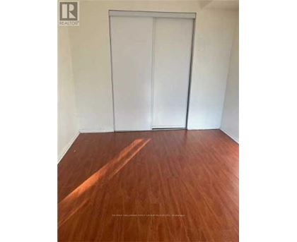 A room with a wooden floor and a white door.