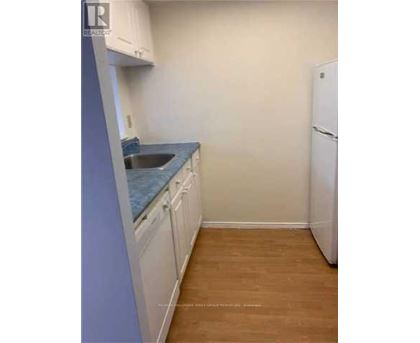 A kitchen with white cabinets and a blue countertop.