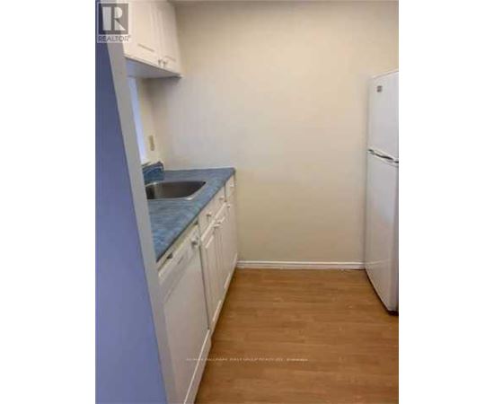 A kitchen with white cabinets and a blue countertop.
