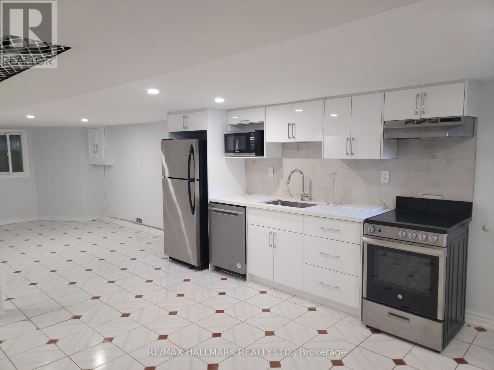 A kitchen with white cabinets and a tiled floor.