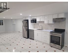 A kitchen with white cabinets and a tiled floor.
