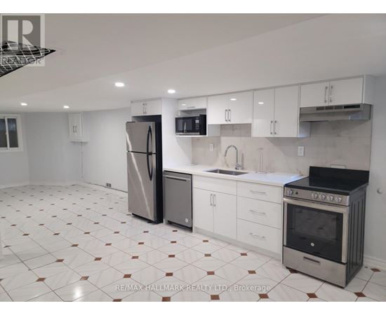 A kitchen with white cabinets and a tiled floor.