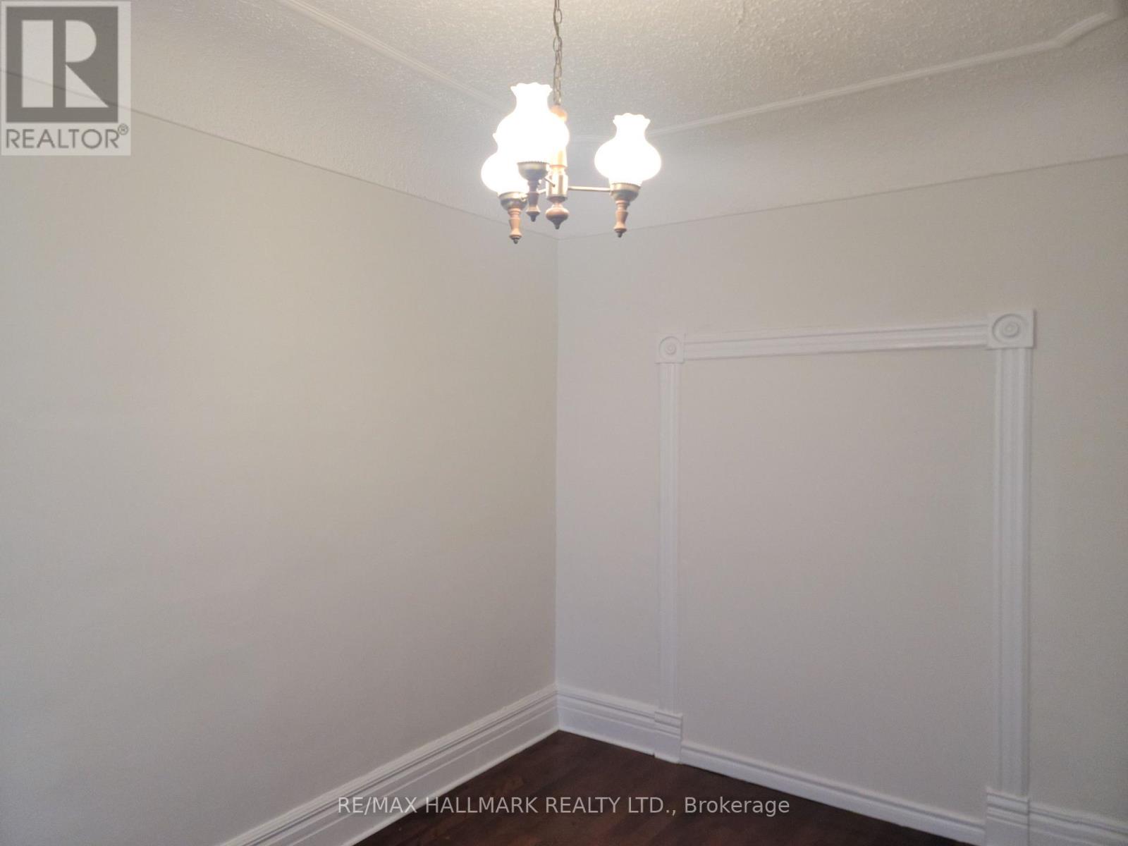 A white wall with a chandelier hanging from the ceiling.