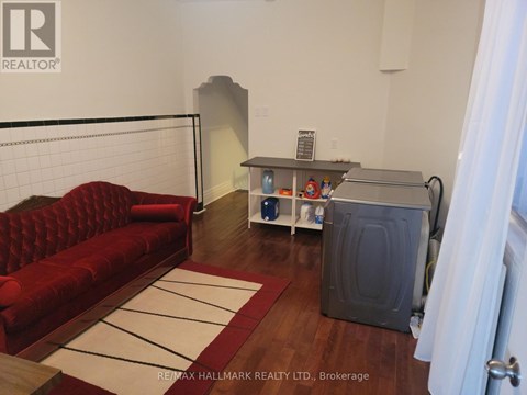 A living room with a red couch and a white rug.